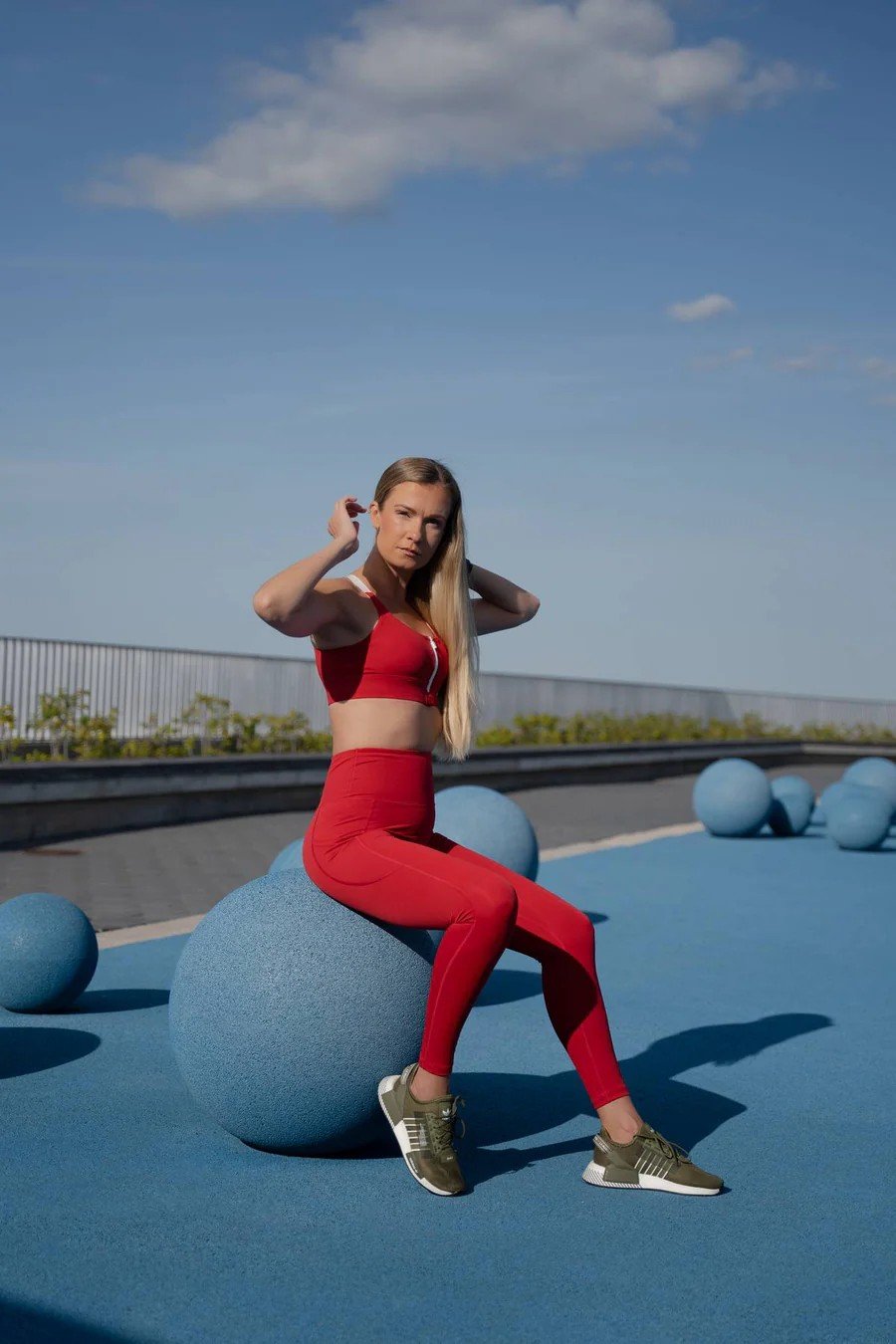 6. Woman standing confidently in Peachlabel 'Cute Cranberry' red leggings and top