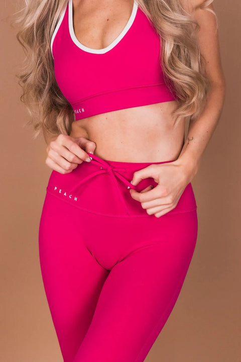 3. Close-up of woman adjusting Peachlabel Raspberry Dream leggings, highlighting waistband