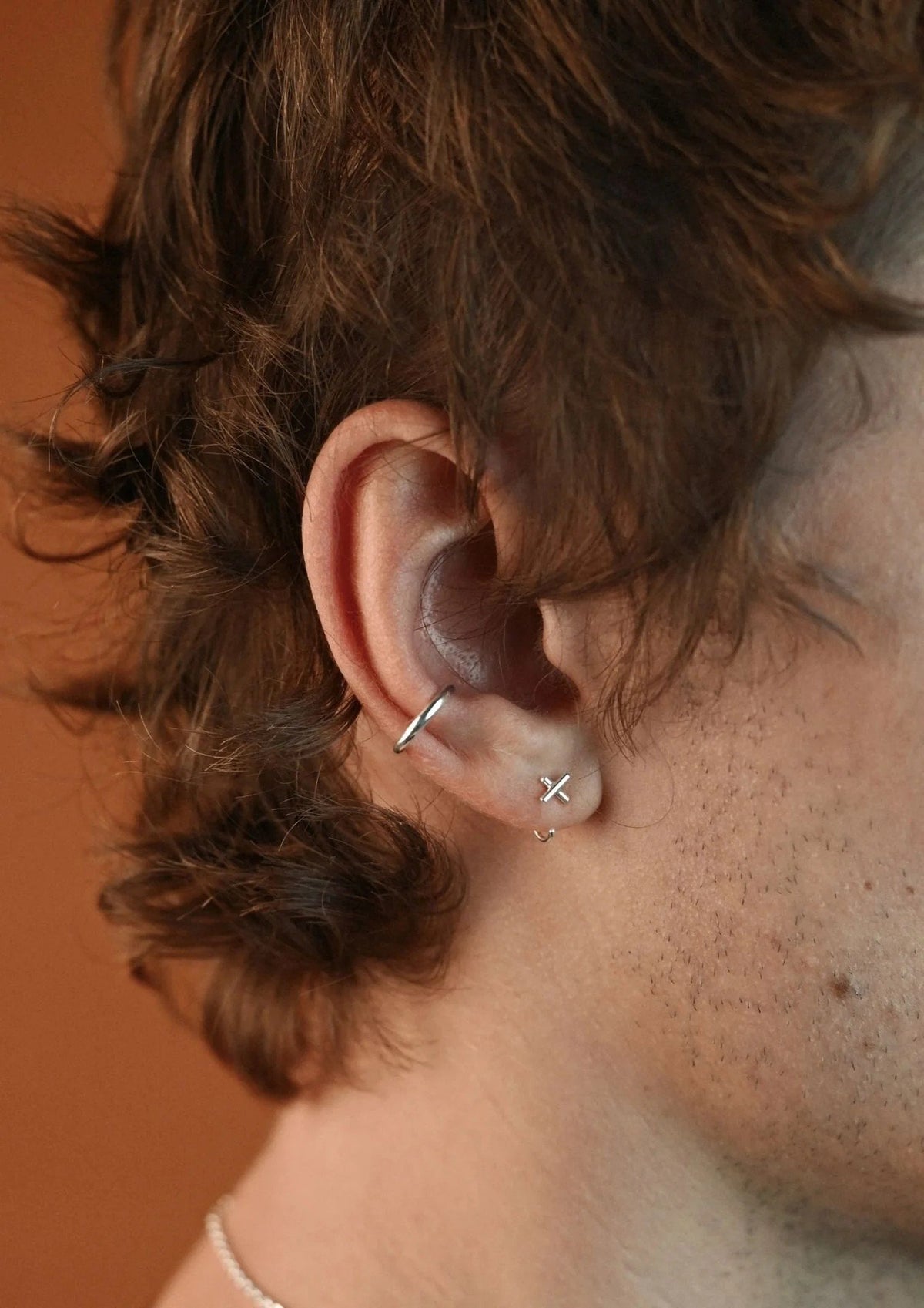 5. Unisex silver Line Ear Cuff by NO MORE worn by male model with short hair