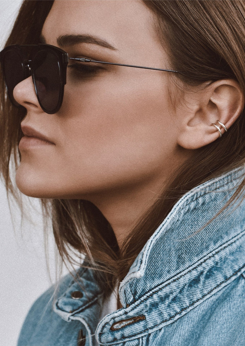 2. Women's silver Line Ear Cuff by NO MORE worn by model with sunglasses and denim jacket