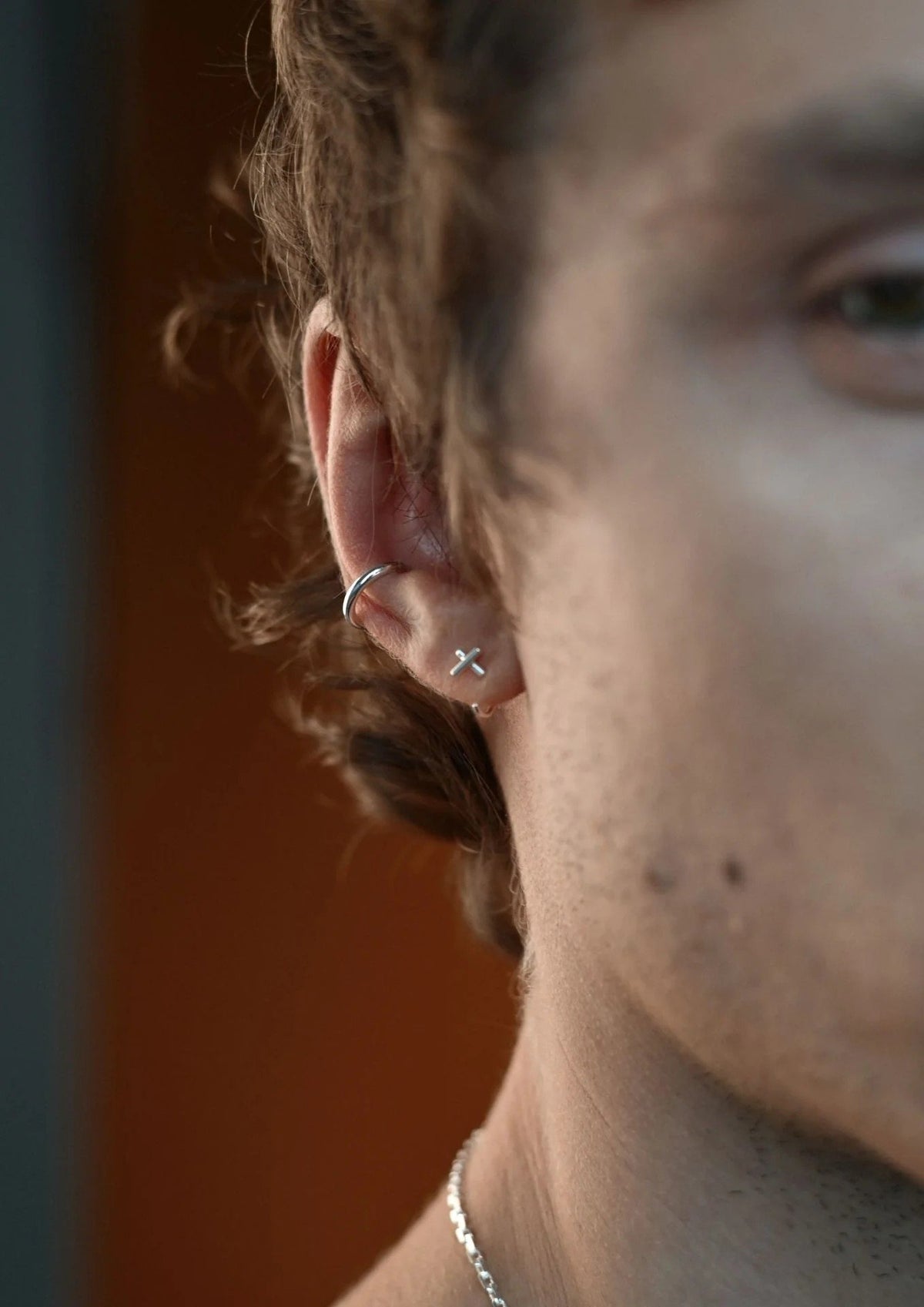 6. Close-up of unisex silver Line Ear Cuff by NO MORE on male model's ear