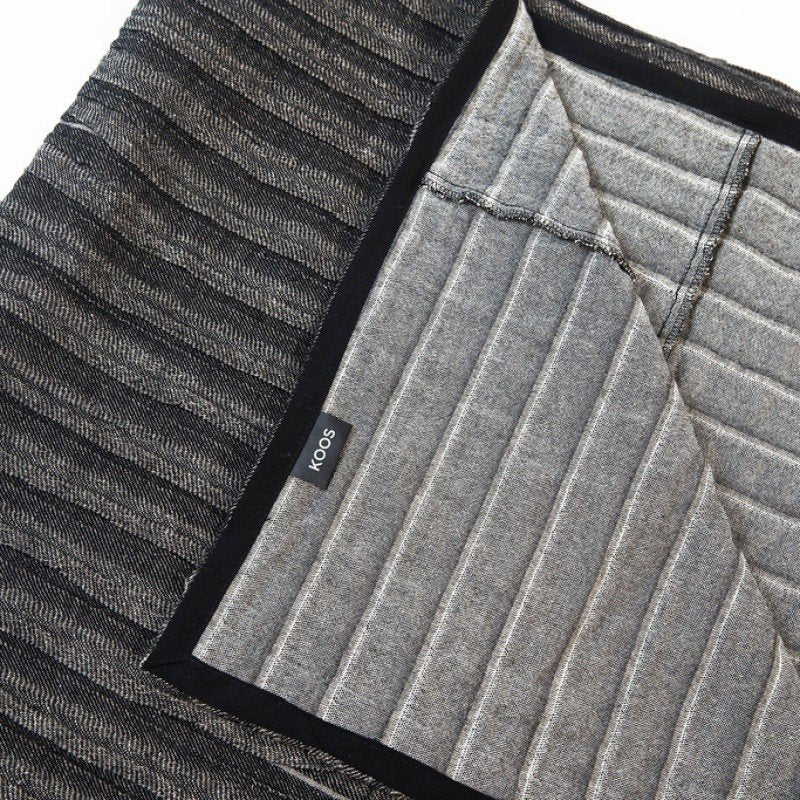 2. Close-up of black and gray corrugated linen-cotton bedcover showing KOOSdisain label and texture