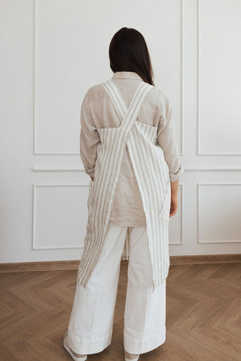 3. Back view of woman wearing striped linen apron with crossed straps