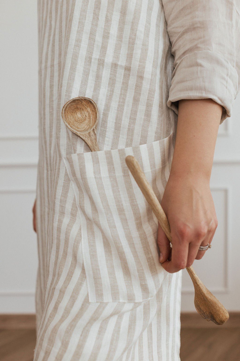 15. Close-up of striped linen apron pocket with wooden spoon