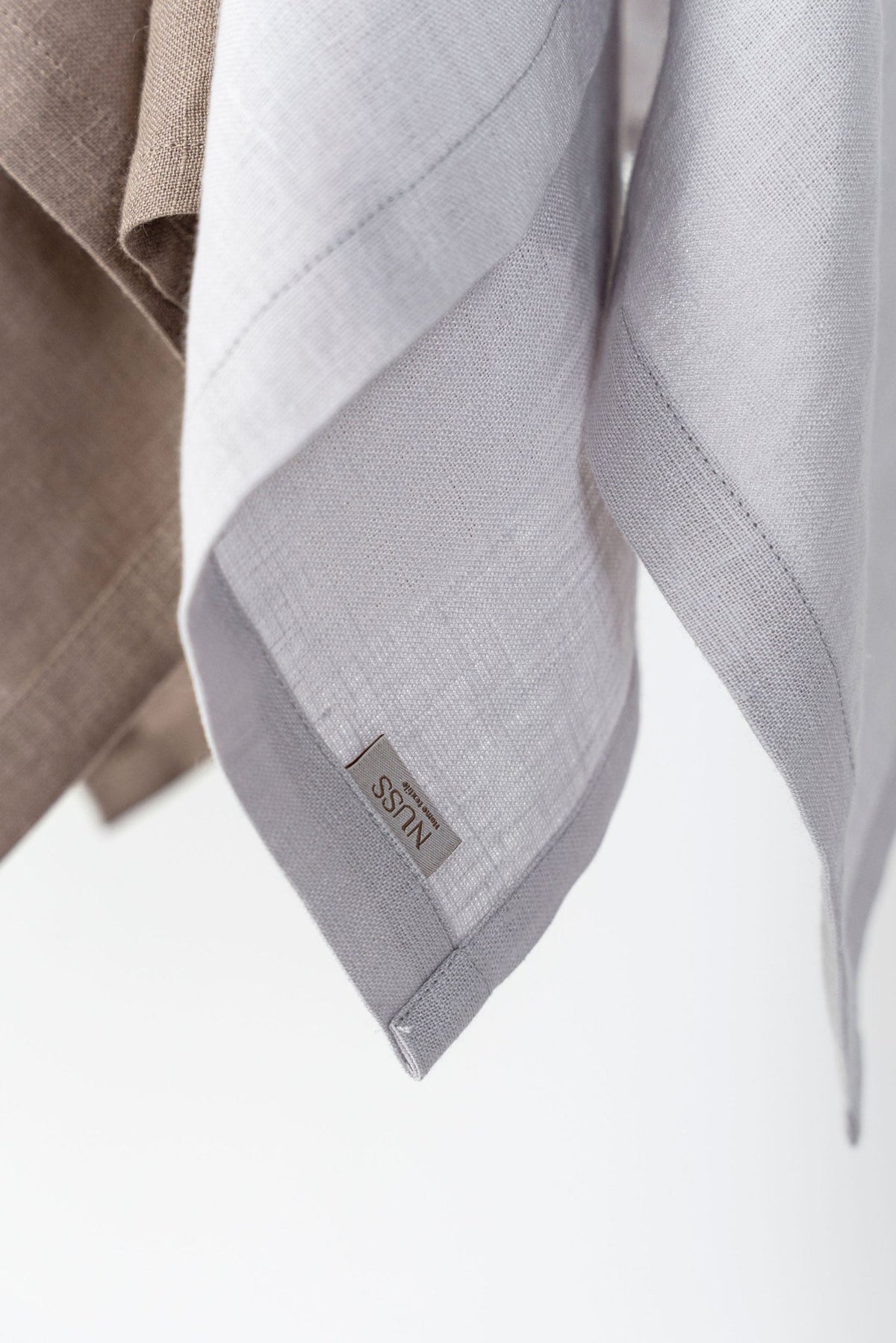 8. Close-up of light gray linen kitchen towel with Nuss brand label
