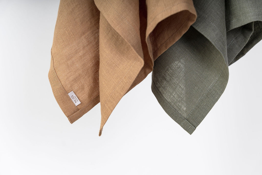 7. Close-up of caramel and olive linen kitchen towels with Nuss brand label