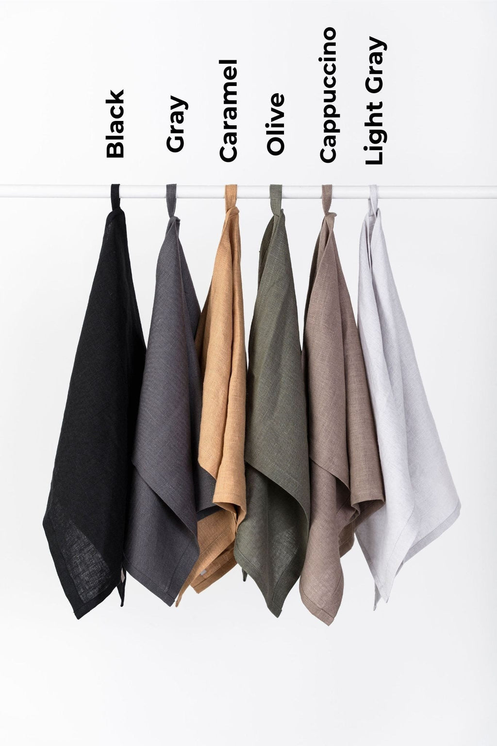 6. Six linen kitchen towels in black, gray, caramel, olive, cappuccino, and light gray hanging on hooks with labels