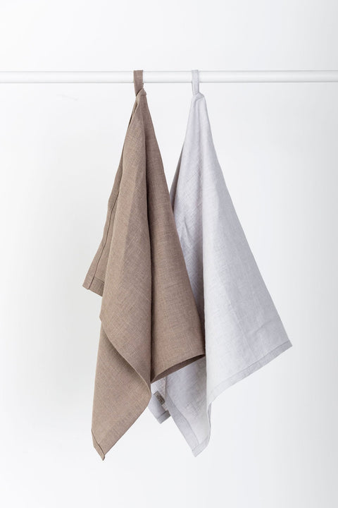 3. Two linen kitchen towels in cappuccino and light gray hanging on a rod