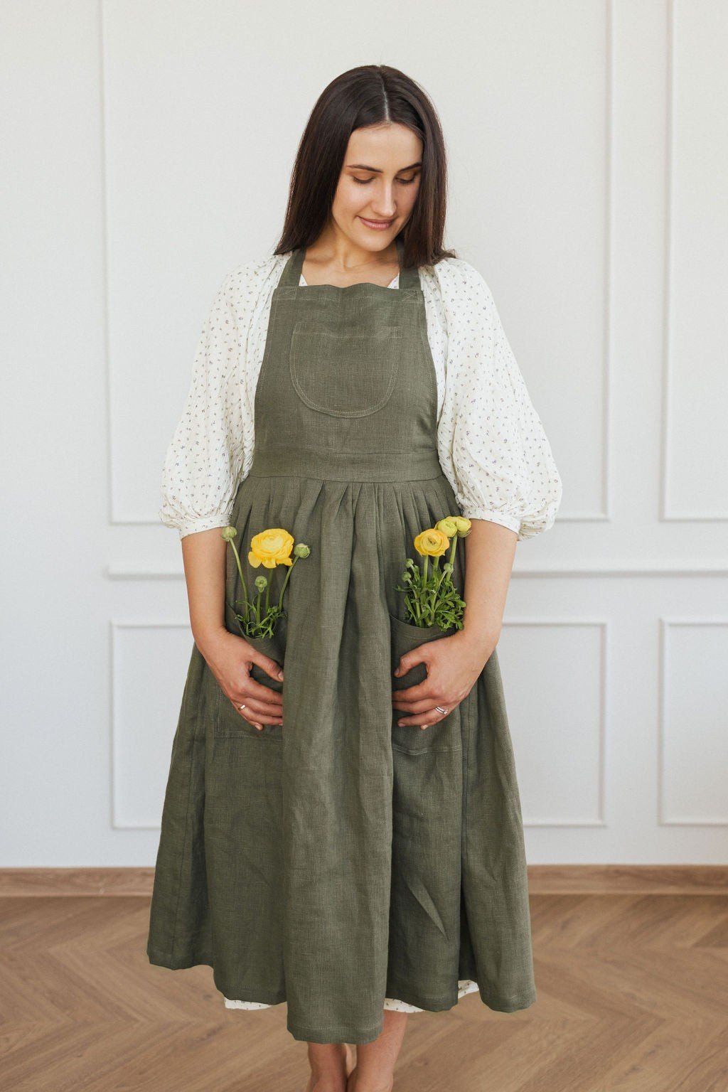 16. Woman in green linen apron with yellow flowers in pockets