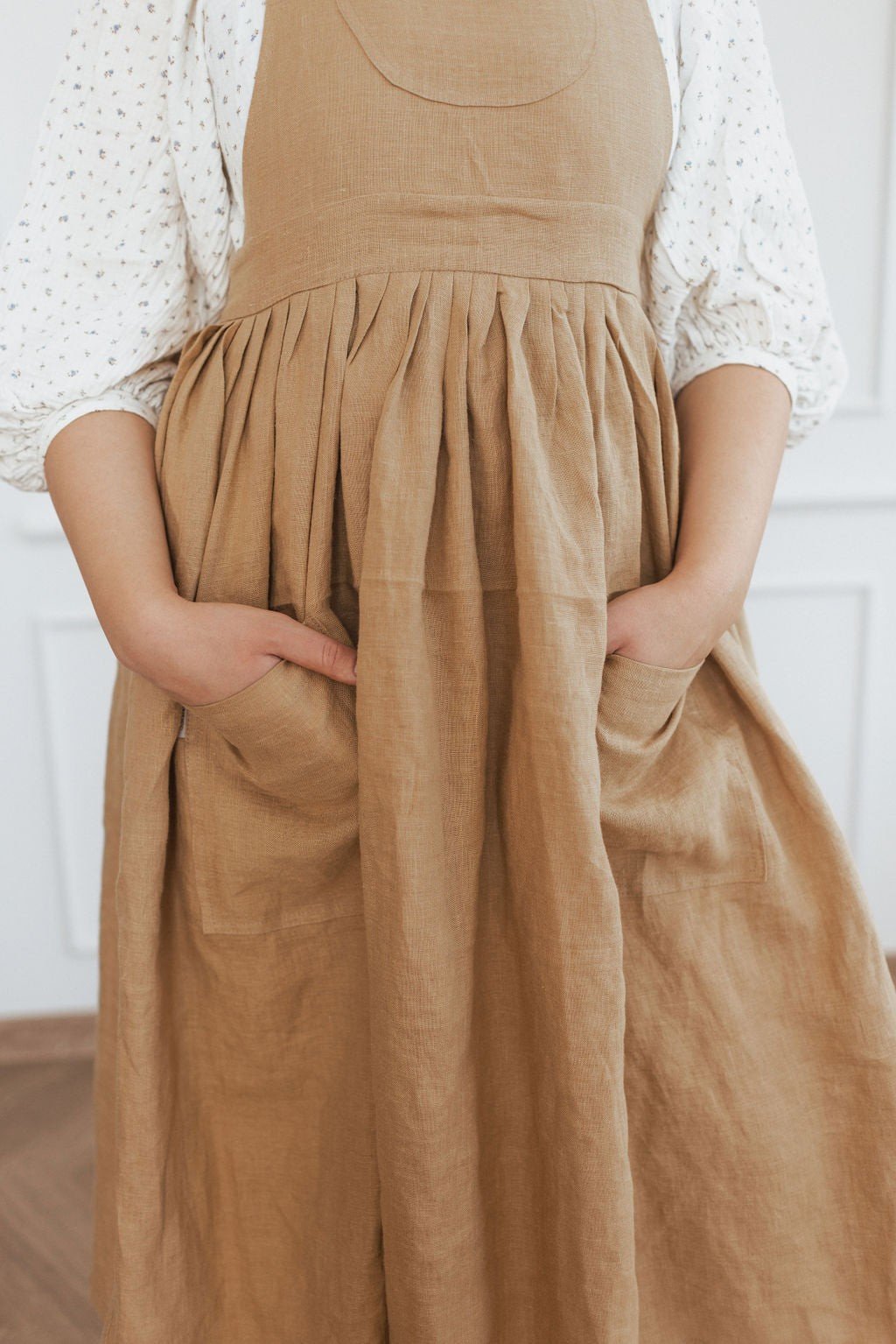 7. Front view of brown linen apron with hands in pockets