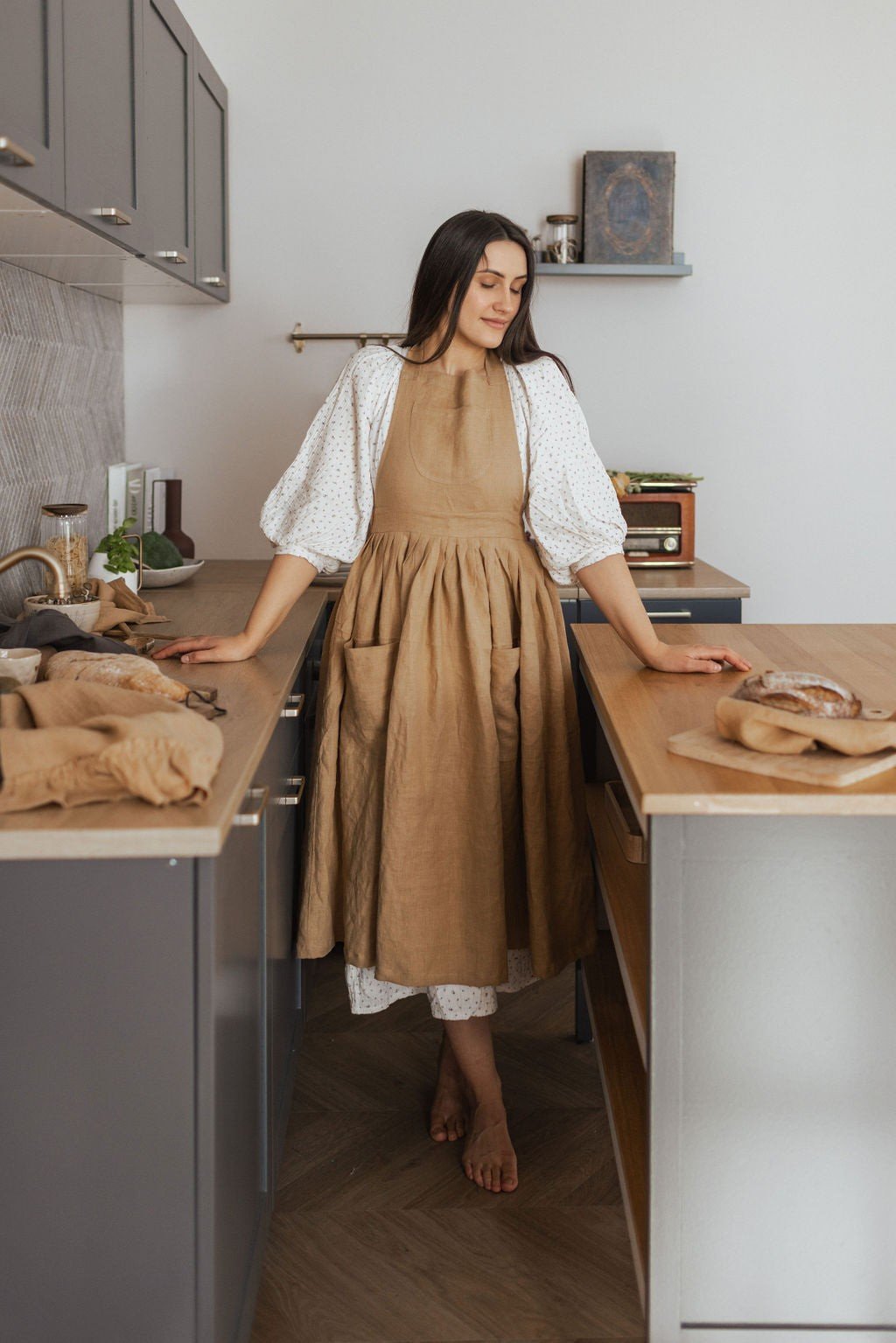 1. Woman wearing brown linen retro apron with pockets in a kitchen setting