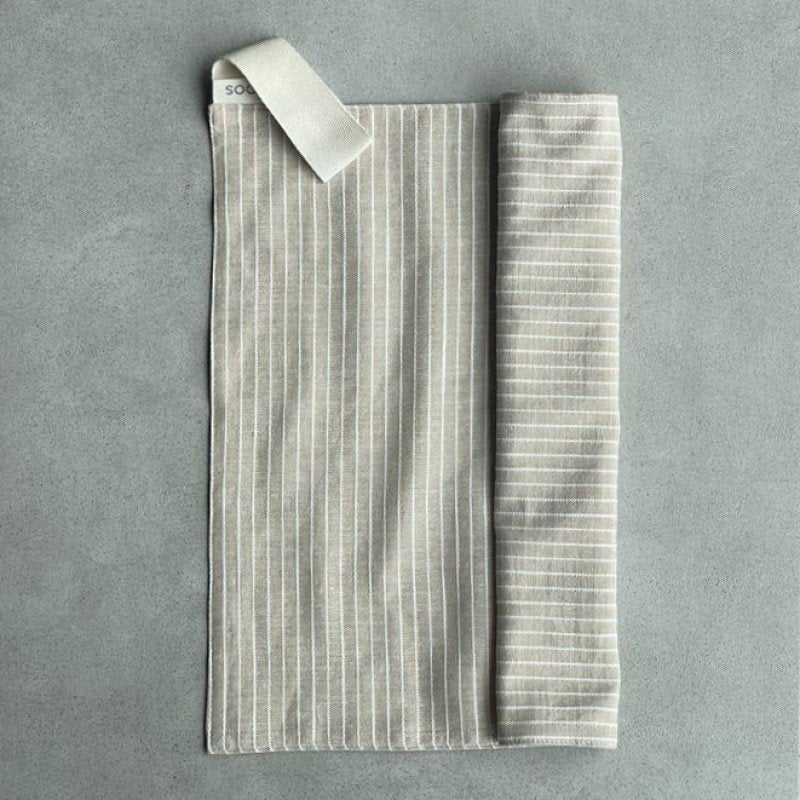 12. Linen sauna seat cover partially rolled, displaying light striped pattern and cotton hook on grey background.