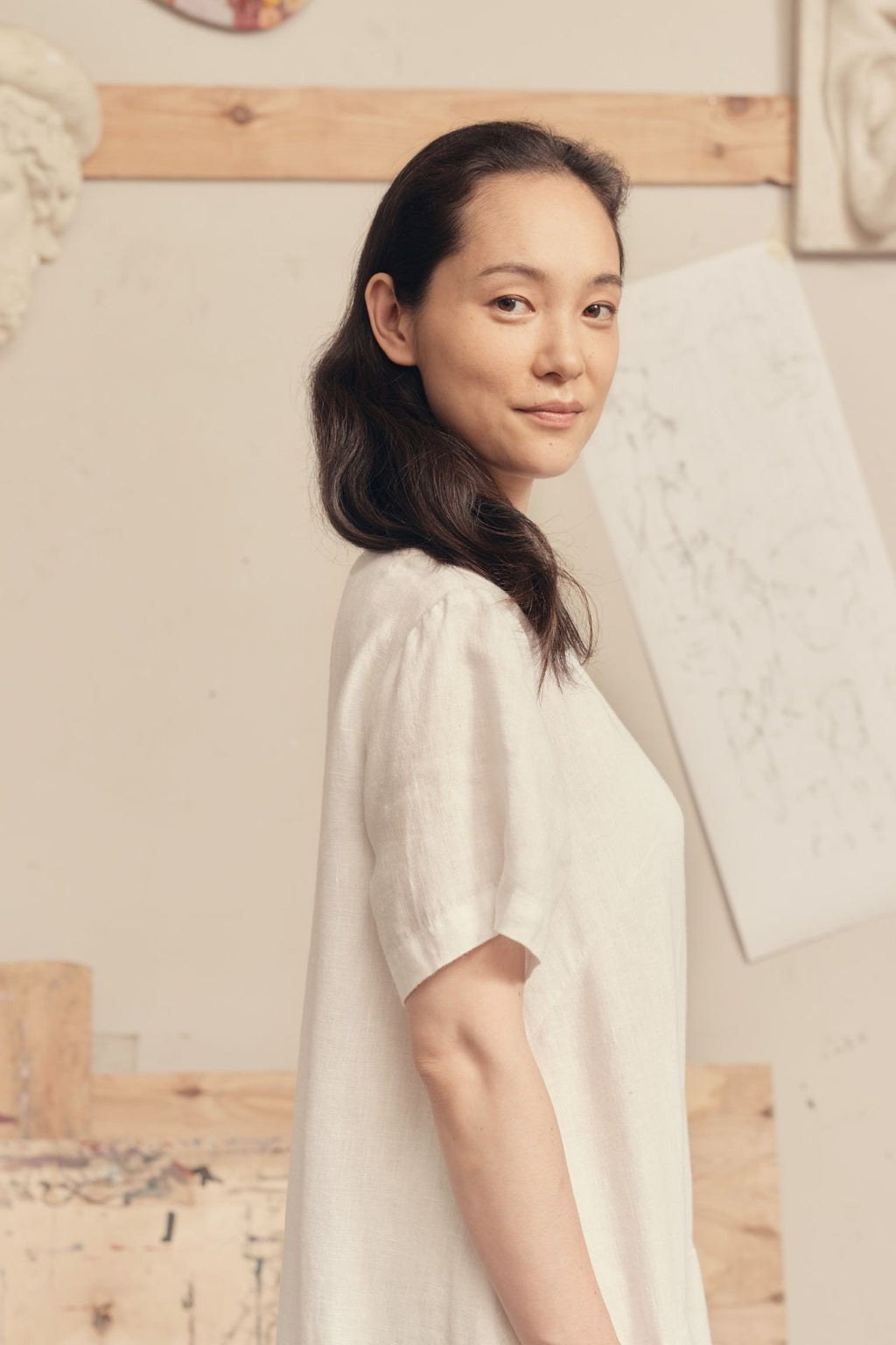 3. Close-up of woman wearing optical white linen dress showing short sleeves and side profile