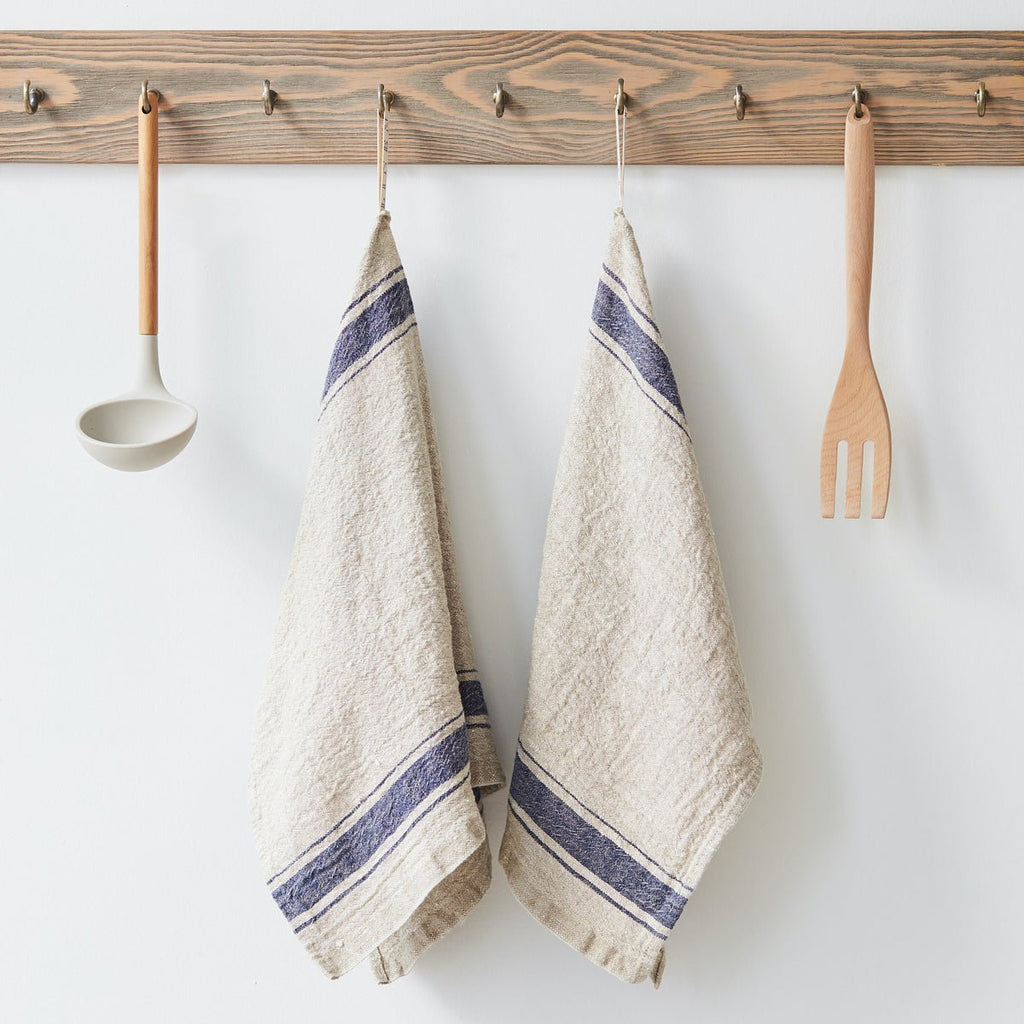 5. Pair of beige linen towels with blue stripes hanging on wooden rack with utensils