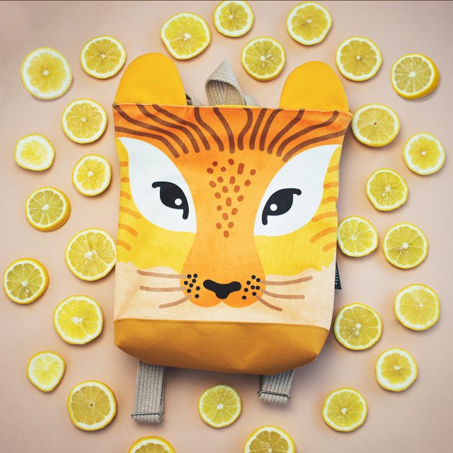 9. Muni lion backpack surrounded by lemons, showcasing design