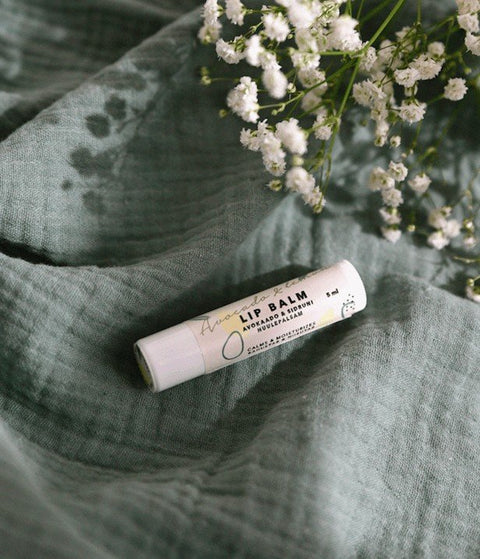 3. BONOBO Avocado & Lemon lip balm on textured green fabric with white flowers