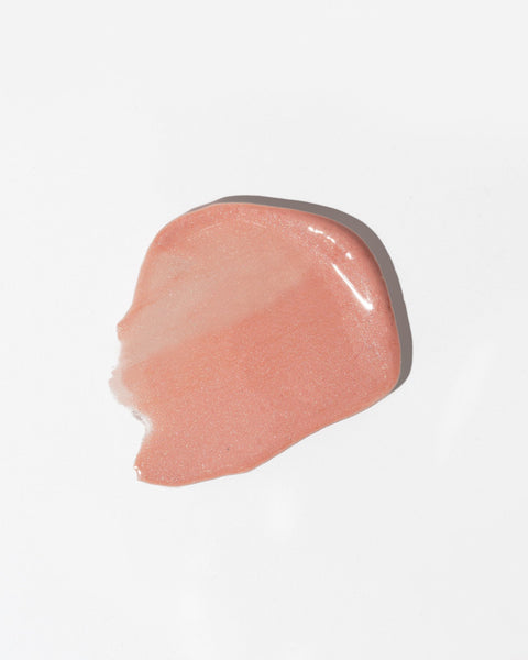2. Close-up of LUUV Lip Gloss Balm swatch in shimmering peach tone on white background