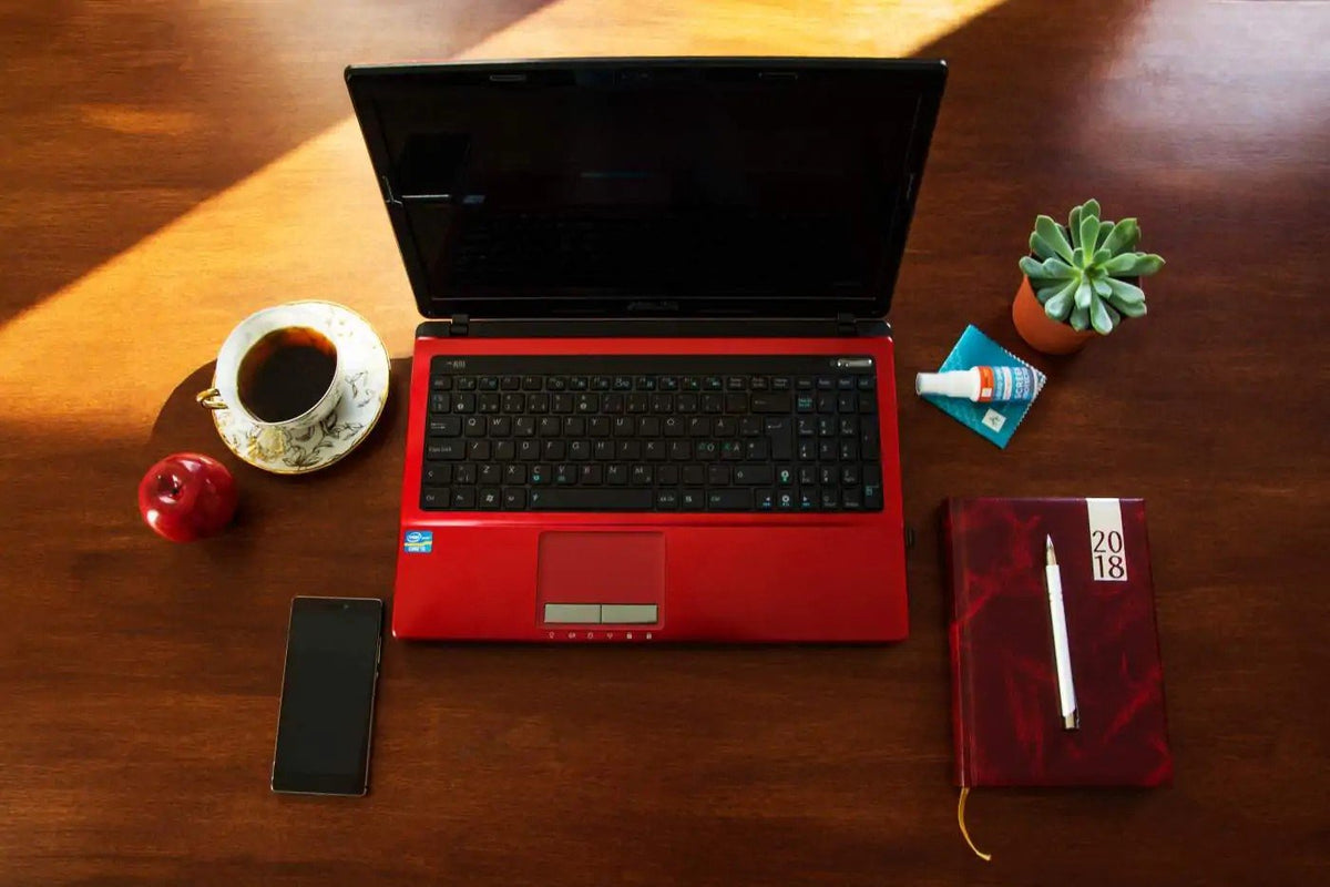 4. Desk setup with red laptop, coffee, and GoGoNano Liquid Shield, highlighting ease of use and application