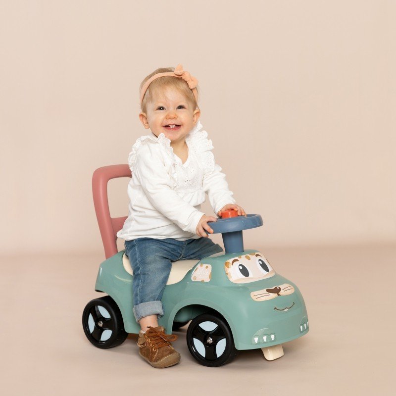 1. Smiling toddler riding Smoby Little Ride-on Pusher in pastel colors, indoor setting