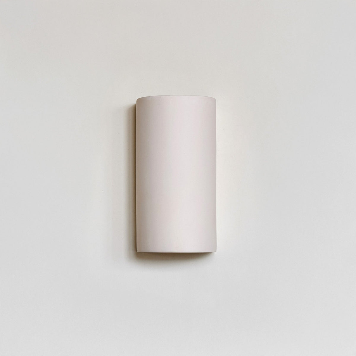 2. Studio shot of ceramic wall light in extra matte white on neutral wall