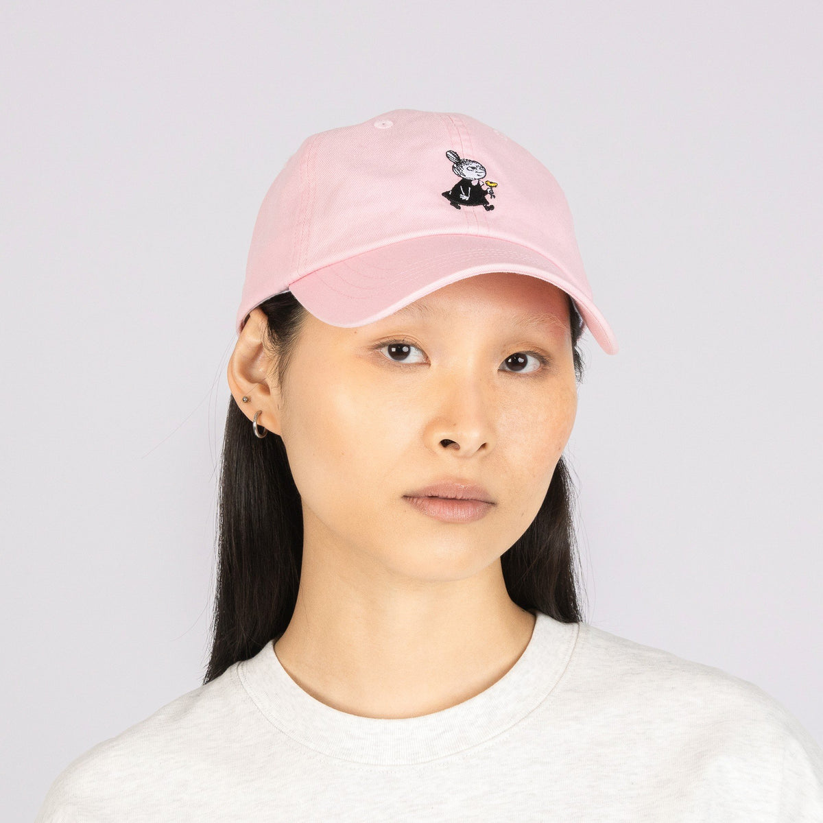 1. Woman wearing Little My Dad Cap in pink by Moomin, front view in studio