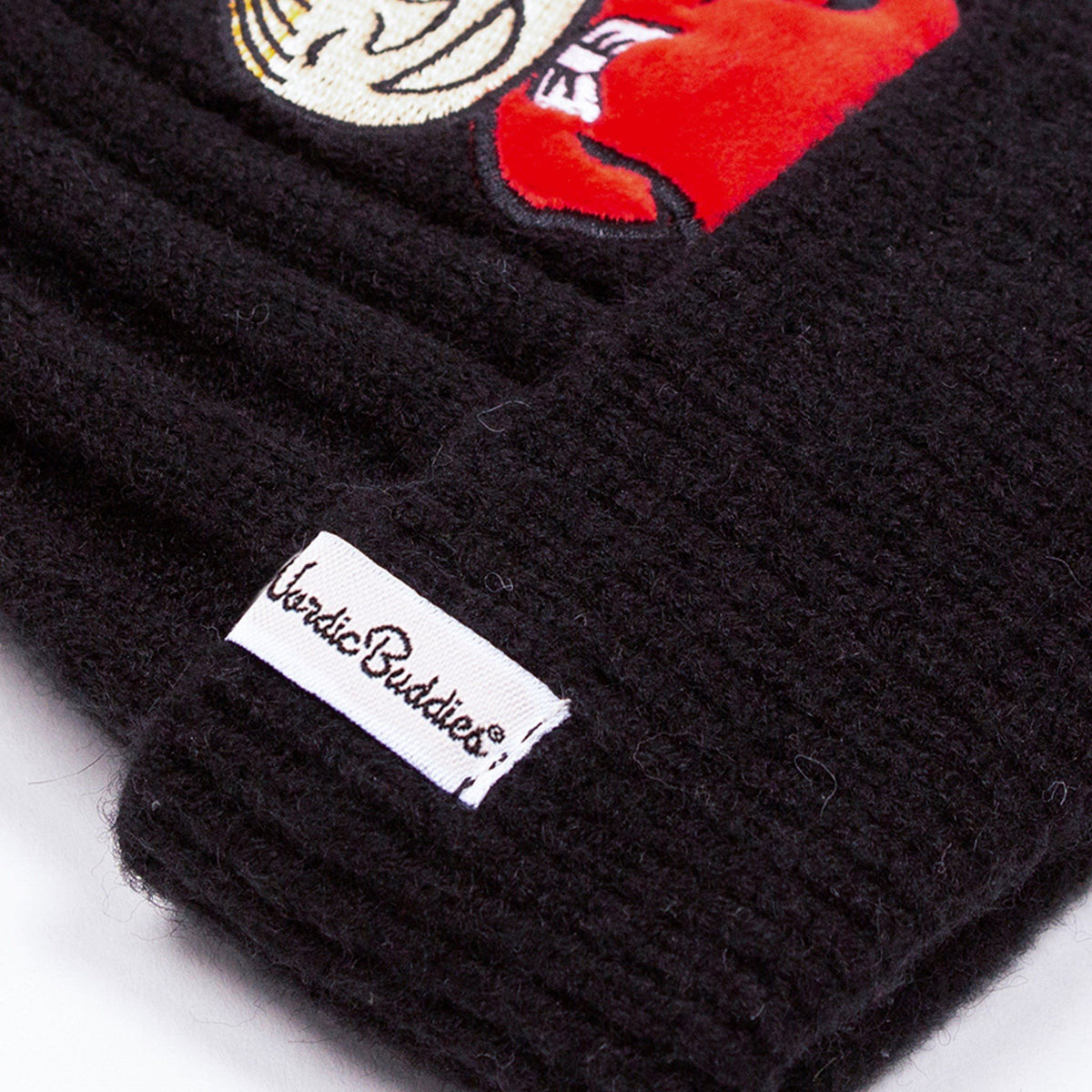 2. Close-up of NordicBuddies label on black beanie with red Little My character detail