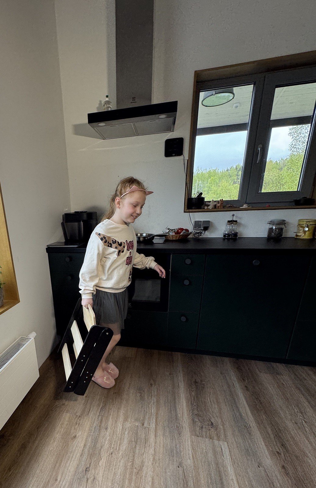 1. Girl carrying folded wooden step stool in a kitchen