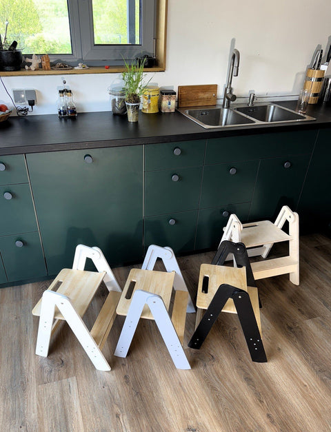 1. Four wooden step stools in different colors placed in a kitchen setting