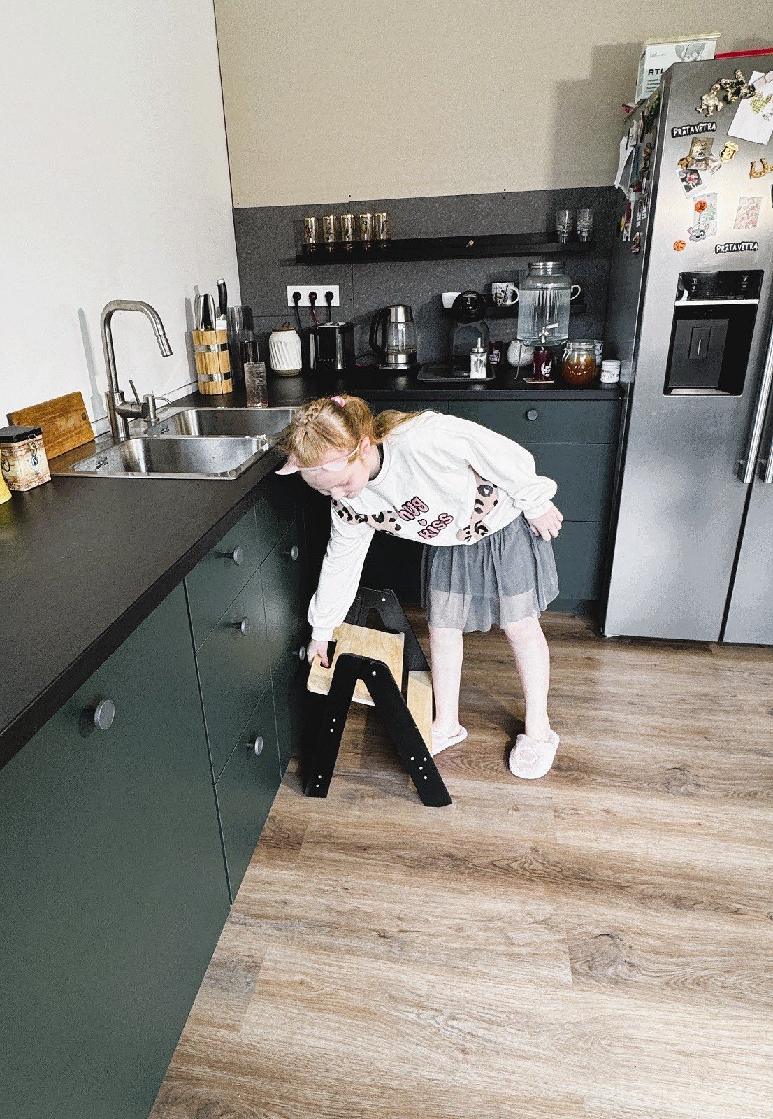 1. Girl setting up wooden step stool in a kitchen