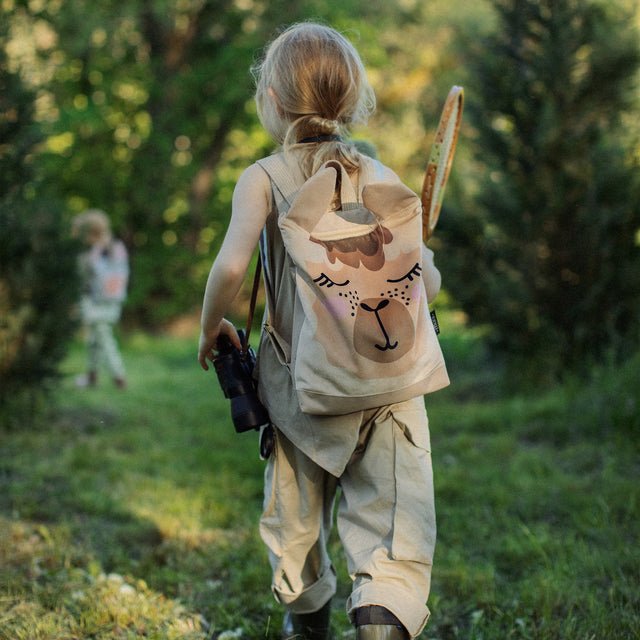 1. Child wearing Muni llama backpack in outdoor setting, showcasing adjustable straps and playful design