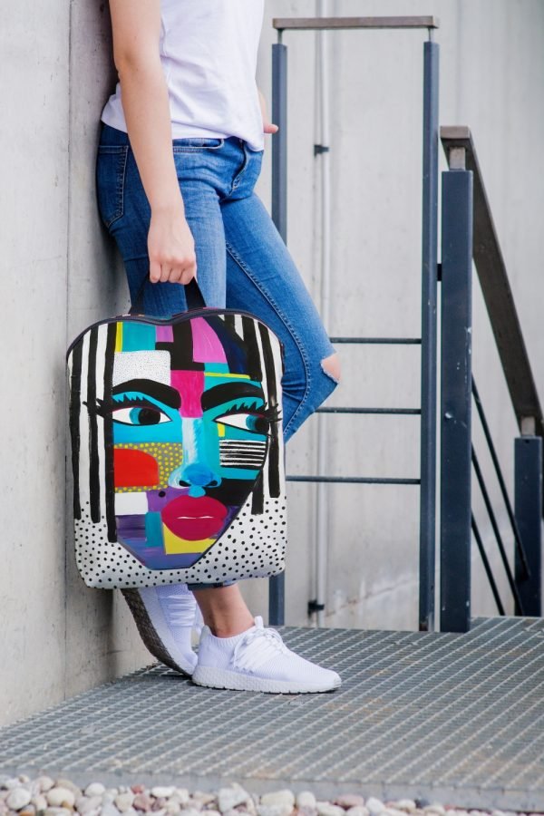 6. Woman holding Garbanota BACKPACK LOLITA against a wall, highlighting colorful design