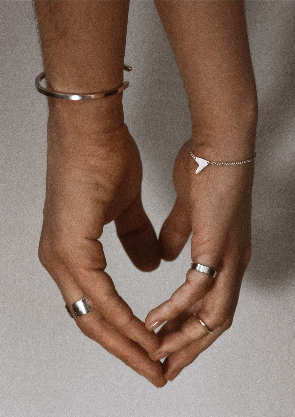 3. Women's Love Bracelet in silver styled with other silver jewelry, shown on hand in monochrome setting