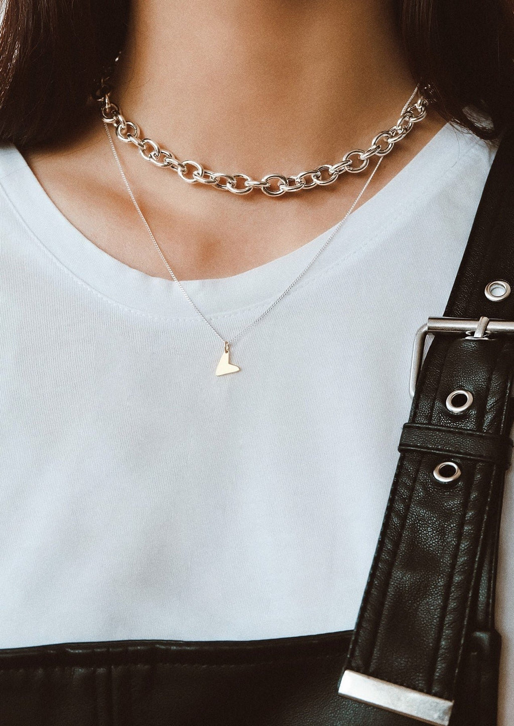 3. Women's Love Necklace in gold by NO MORE, layered with a silver chain over a white top
