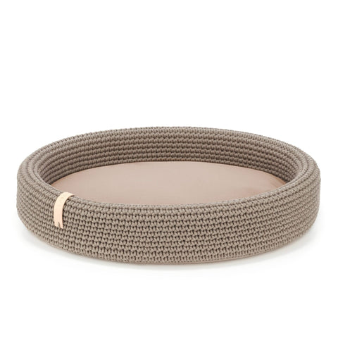 2. Light brown oval dog bed by Labbvenn made of braided cotton and polyester with removable cushion, shown in studio setting highlighting texture and design