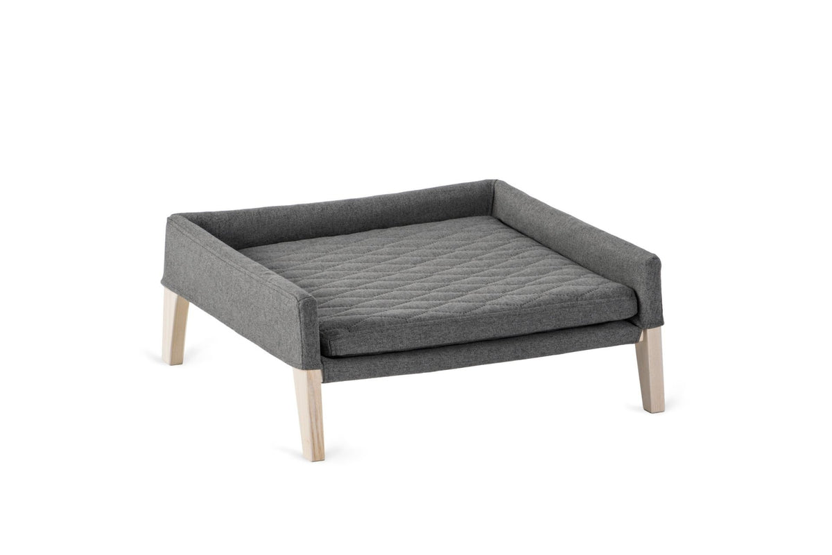 2. Anthracite dog and cat bed with quilted pillow and ash wood legs, designed for small pets, shown in studio setting highlighting minimalist design and comfort features