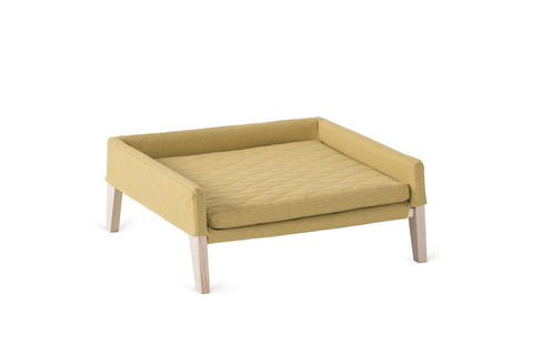 2. Honey-colored pet bed for cats and small dogs with quilted cushion and ash wood frame, shown in studio setting highlighting minimalist design and comfort features