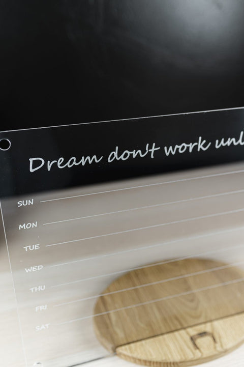 3. Close-up of acrylic school planner with quote 'Dream don't work unless you do' and weekly schedule, on wooden stand