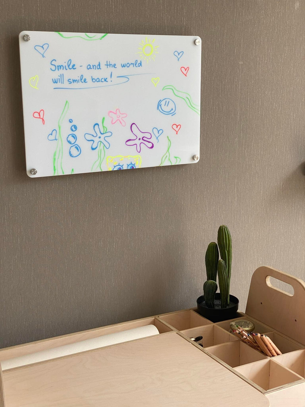 5. Wall-mounted Luula planner with colorful drawings and motivational text above desk