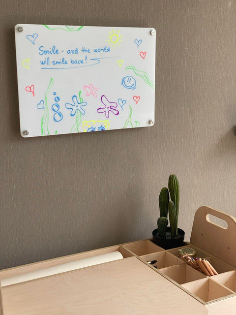 5. Wall-mounted Luula planner with colorful drawings and motivational text above desk