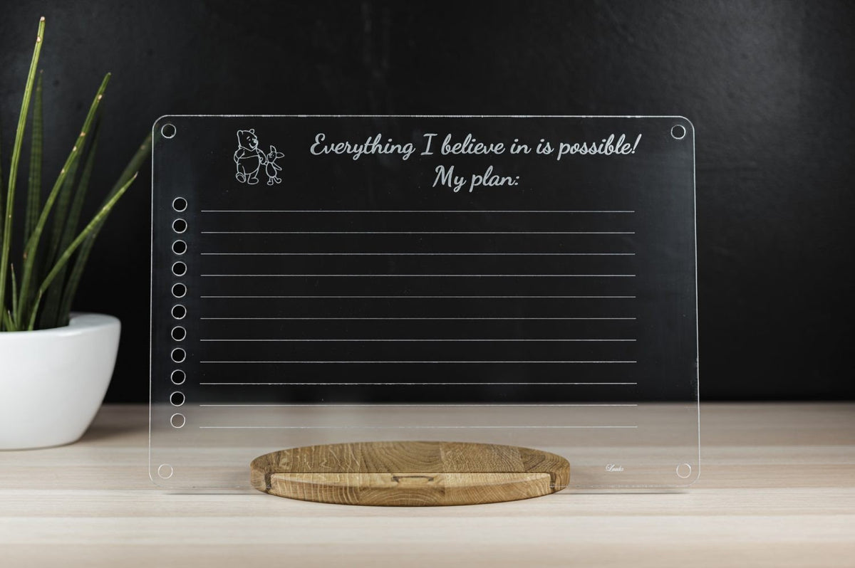 1. Luula acrylic toddler planner on wooden stand with motivational text and plant in background