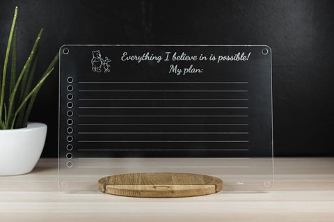1. Luula acrylic toddler planner on wooden stand with motivational text and plant in background