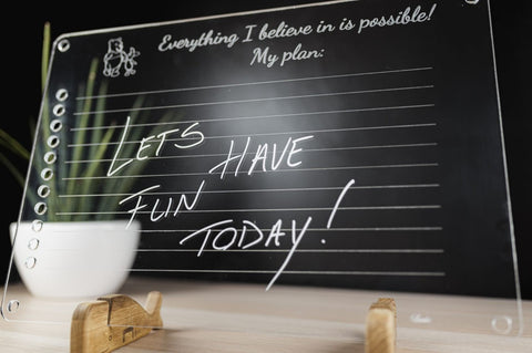 2. Close-up of Luula acrylic planner with handwritten message 'Let's have fun today!' on wooden stand