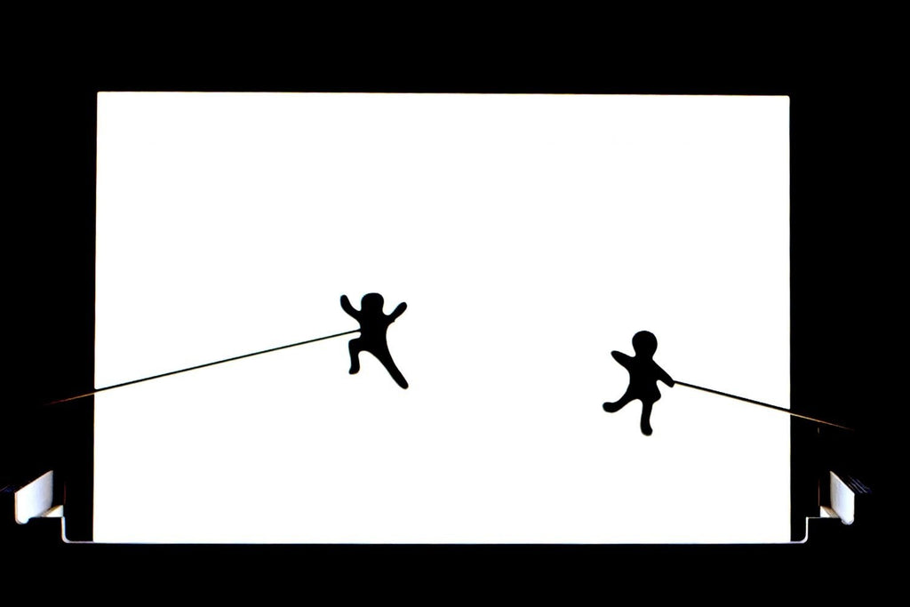 3. Silhouette figures on Luula light board creating shadow play effect