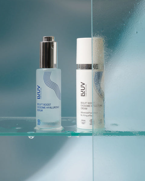 4. LUUV BioLift Exosome-Hyaluronic Serum and Cream on a glass shelf with water droplets