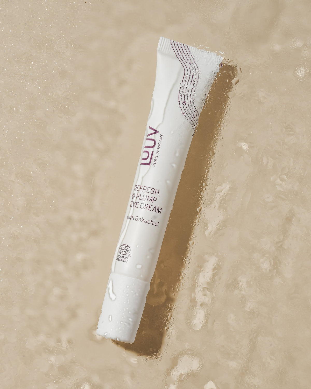 1. LUUV Refresh & Plump Eye Cream tube with Bakuchiol on a wet surface, highlighting COSMOS ECOCERT Organic certification