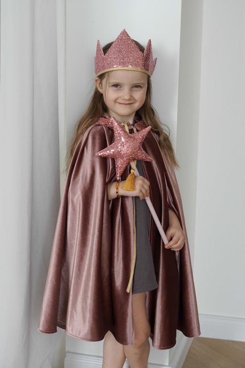 1. Child dressed in cosmic pearl cape with pink crown and star wand, showcasing the velour fabric and magical theme