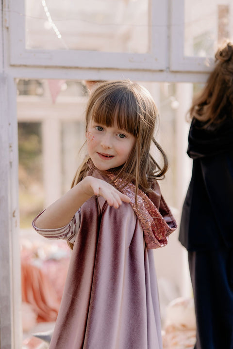 1. Child wearing cosmic pearl cape with hood indoors, showing playful and magical design by moi mili