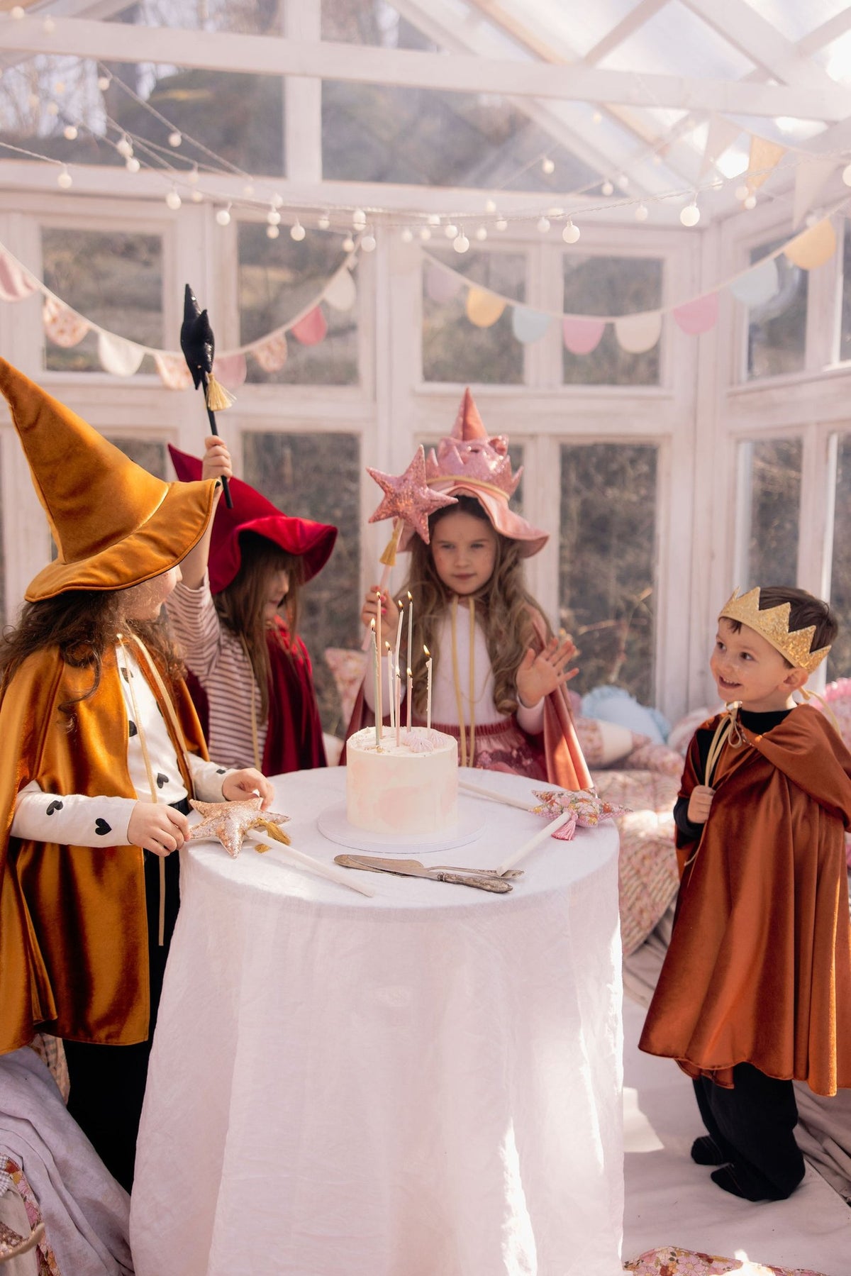 12. Children in golden and red capes celebrating around table