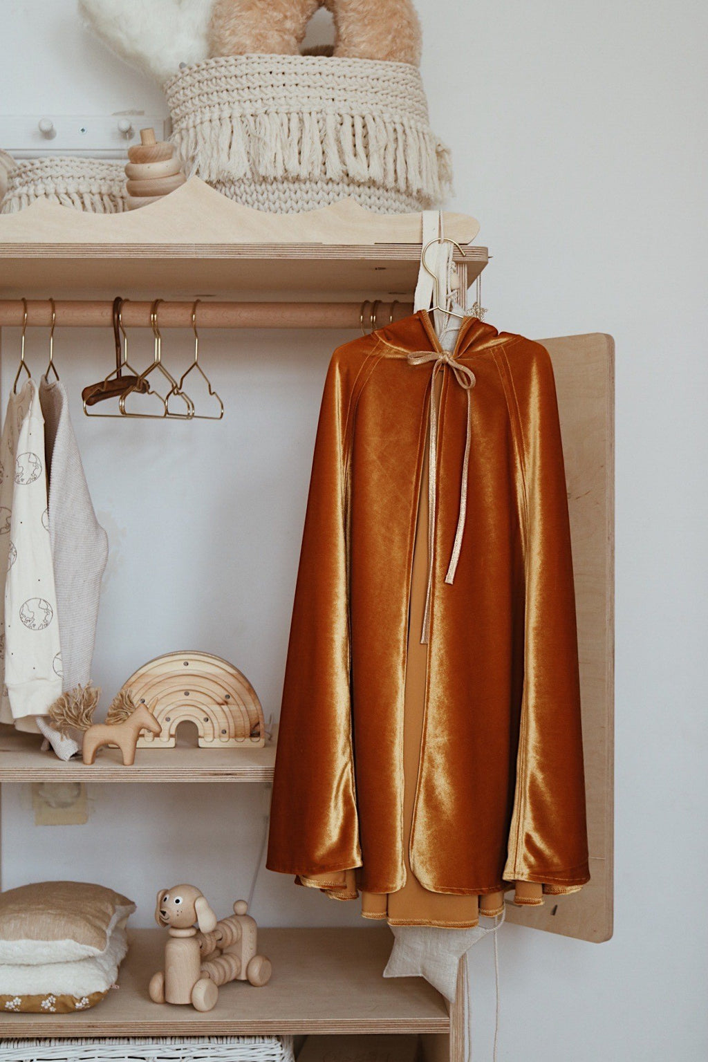 2. Golden cape hanging on wooden rack in cozy room