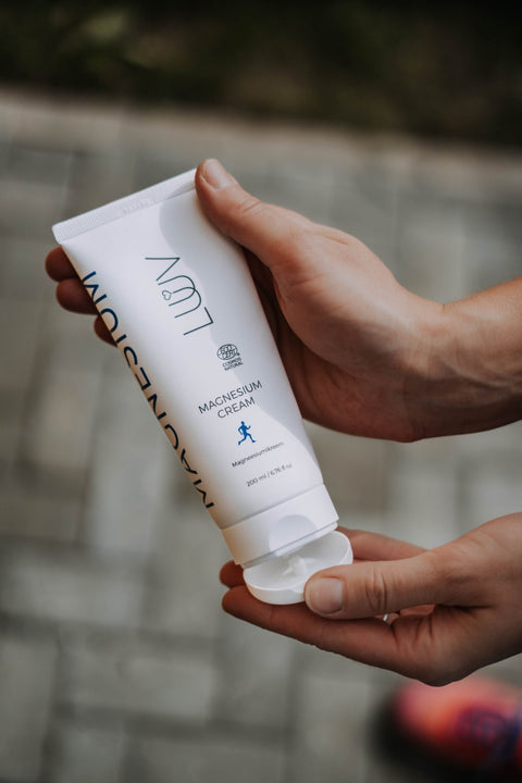 3. Hands holding LUUV Magnesium Cream tube with open cap